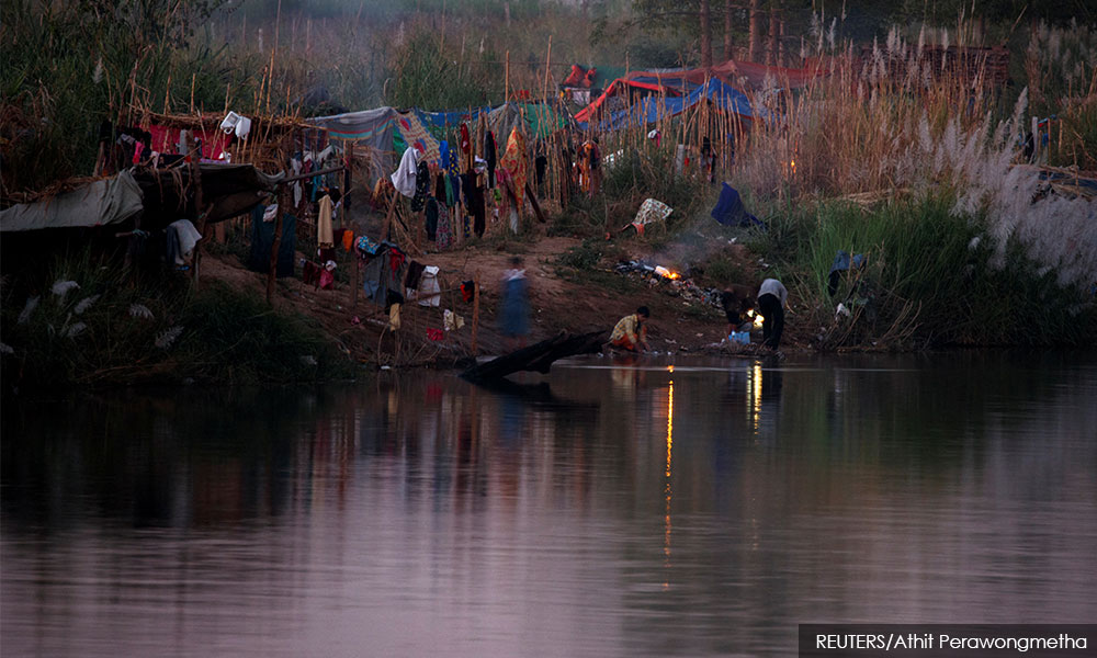 Fleeing violence in Myanmar, thousands camp along Thai border river